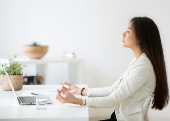 Woman meditating at office desk