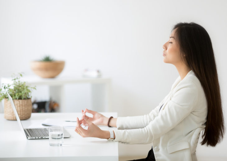 Woman meditating at office desk