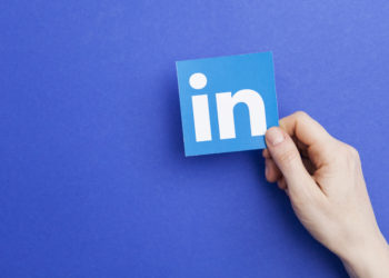 Person holding up printed LinkedIn logo